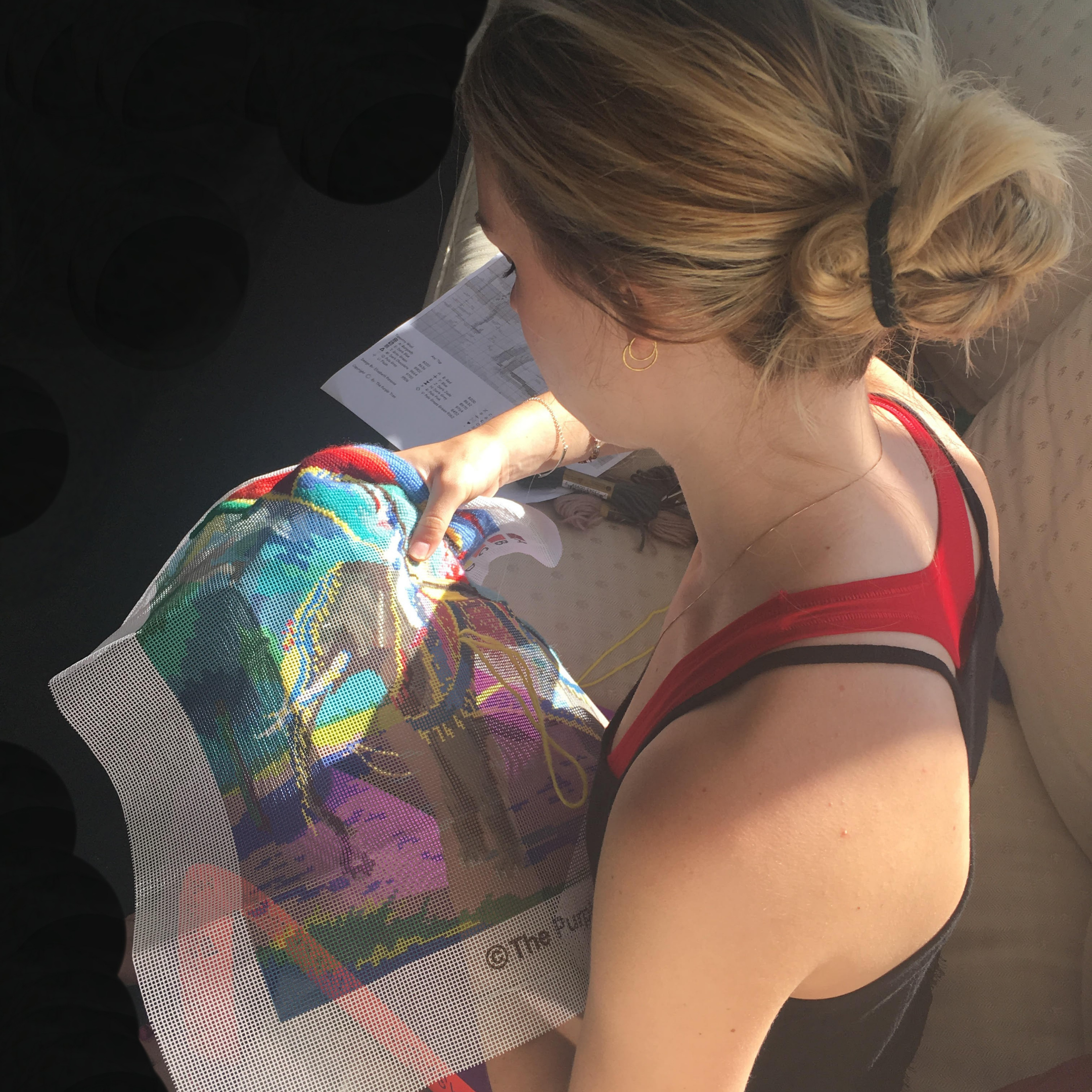 Woman holding a colorful bag with a horse design, sitting in a vehicle.