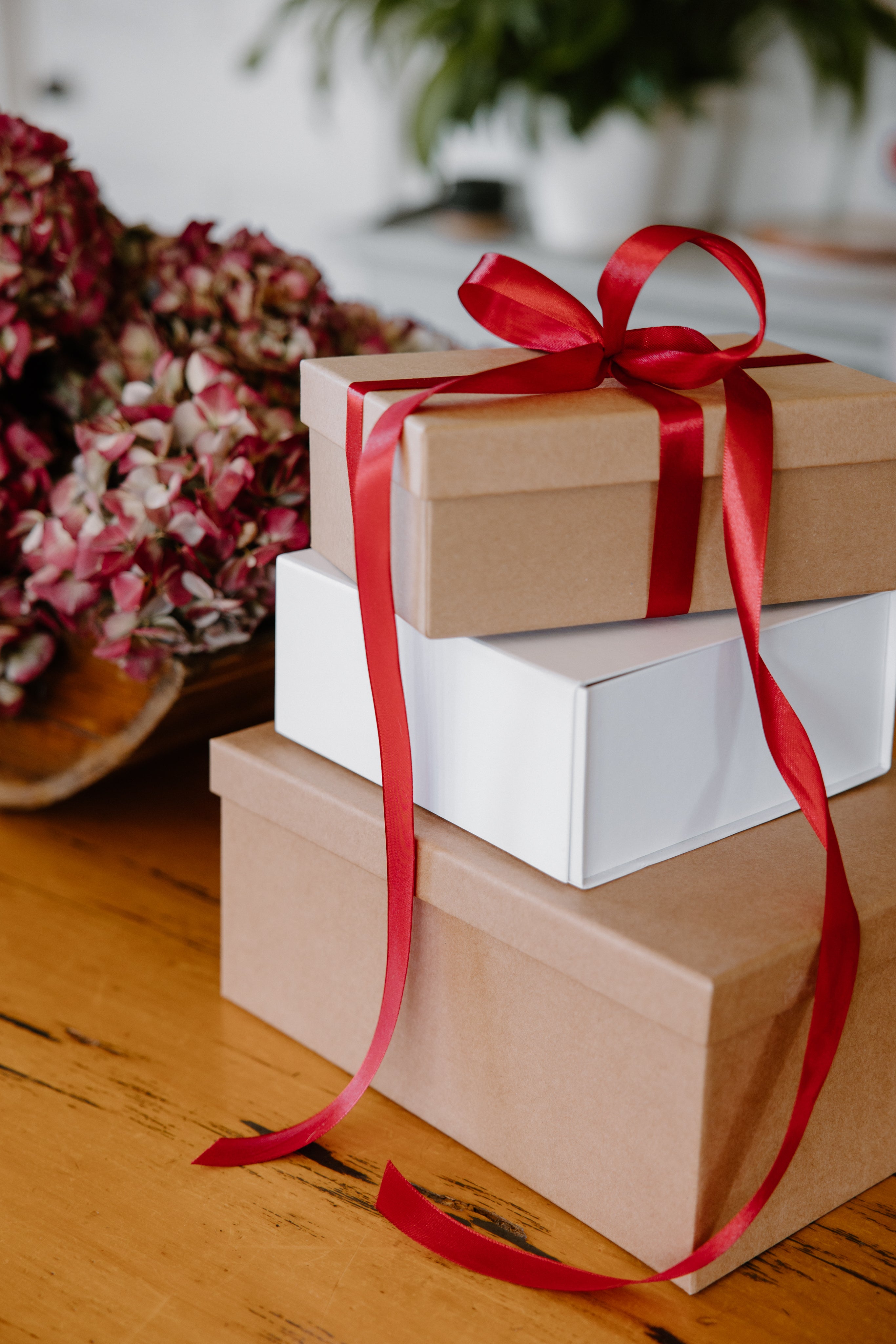 gift boxes stacked on a table with red ribbon