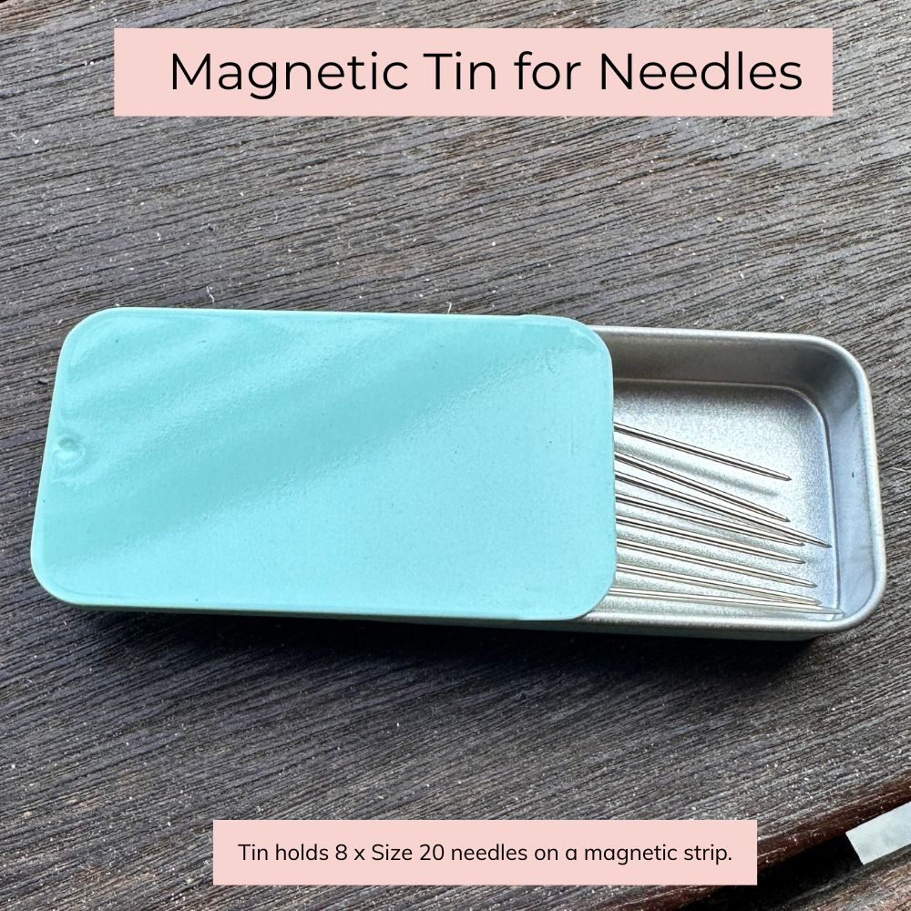 Magnetic tin for needles with a turquoise lid on a wooden surface