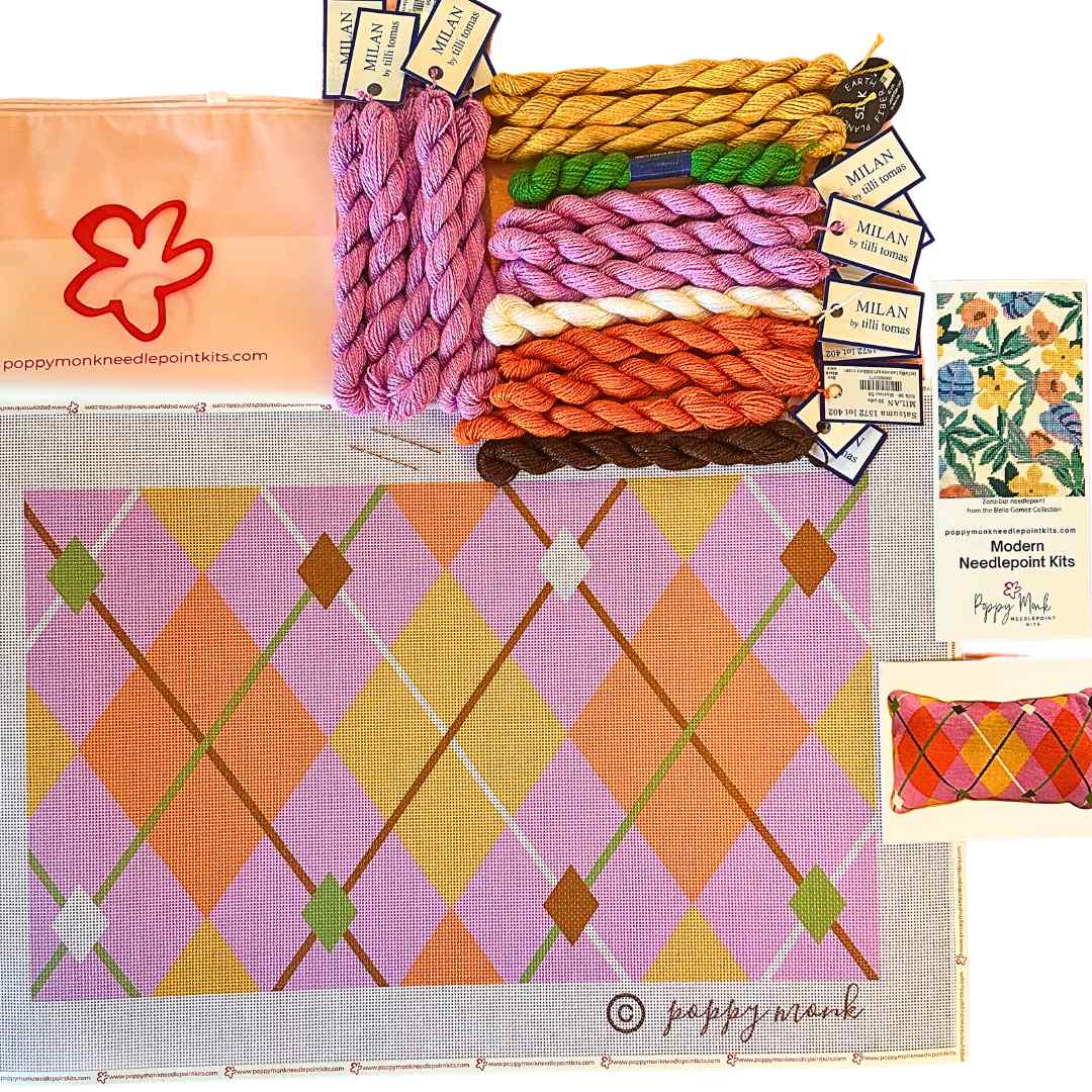Needlepoint kit with yarn, canvas, and accessories on a white background