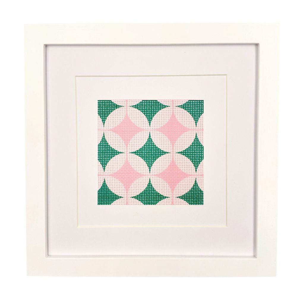 Geometric design needlepoint canvas ion steel green and pinks shown in a white frame