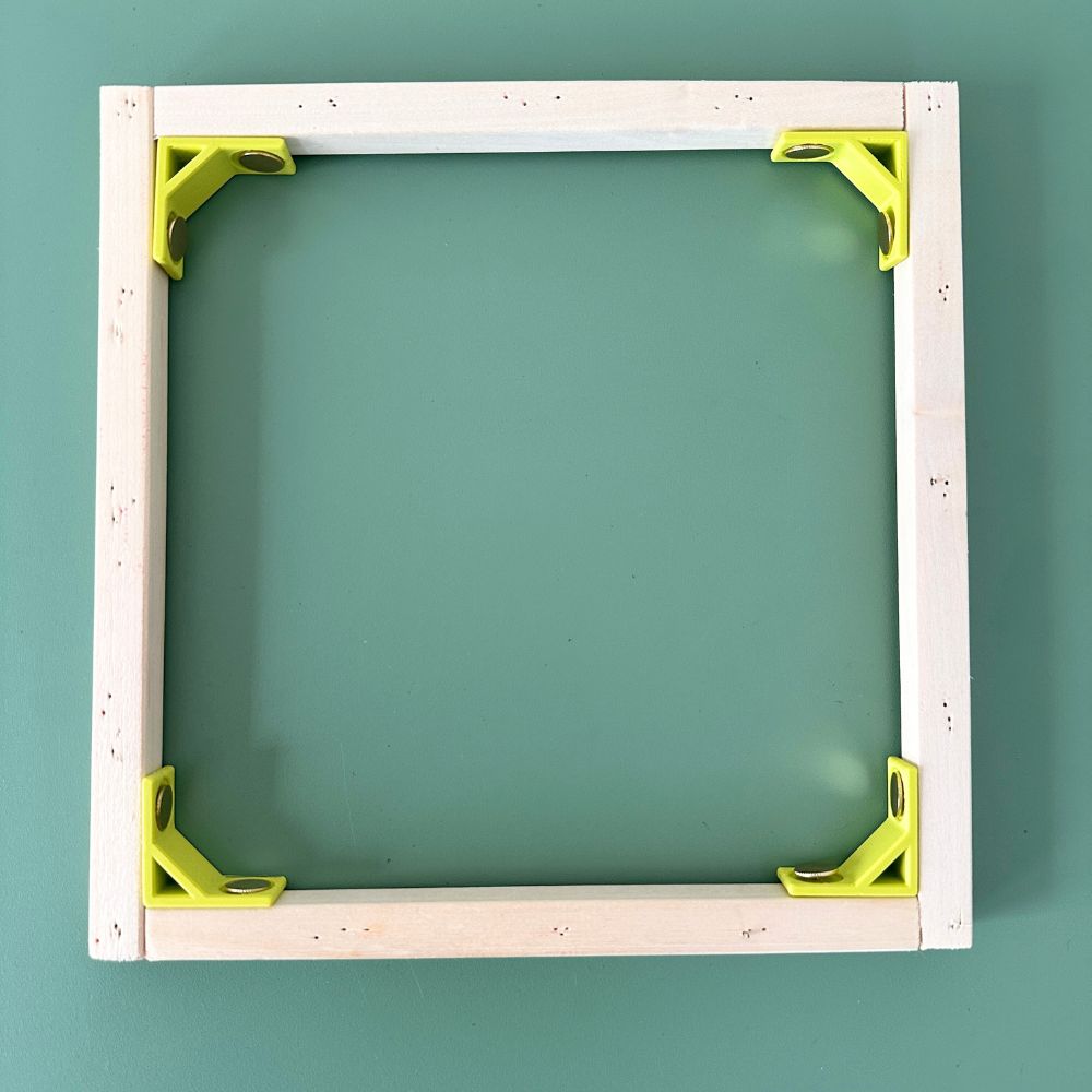 Wooden frame with green brackets on a teal background