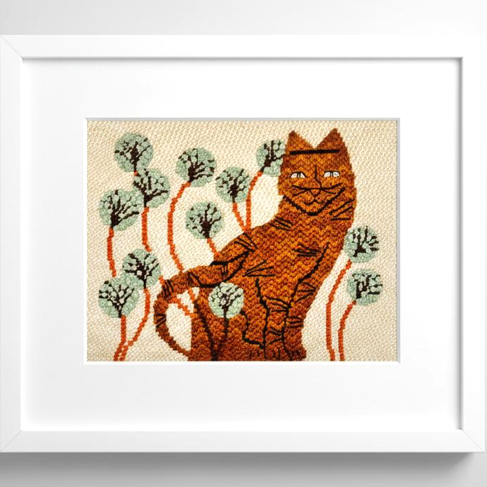 Framed needlepoint of a ginger tabby cat