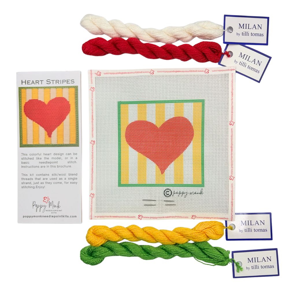 Heart-themed needlepoint kit with colorful yarn and brand tags on a white background