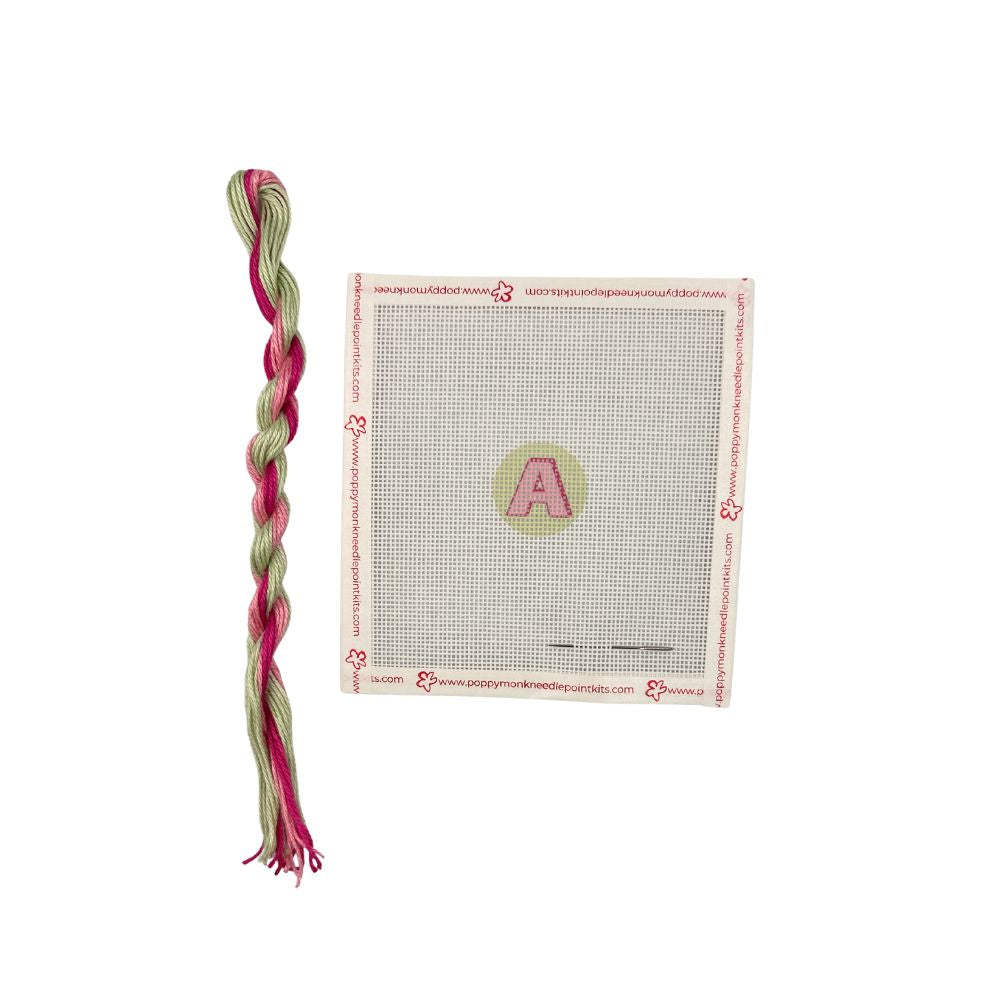 Braided pink and green yarn with a package on a white background