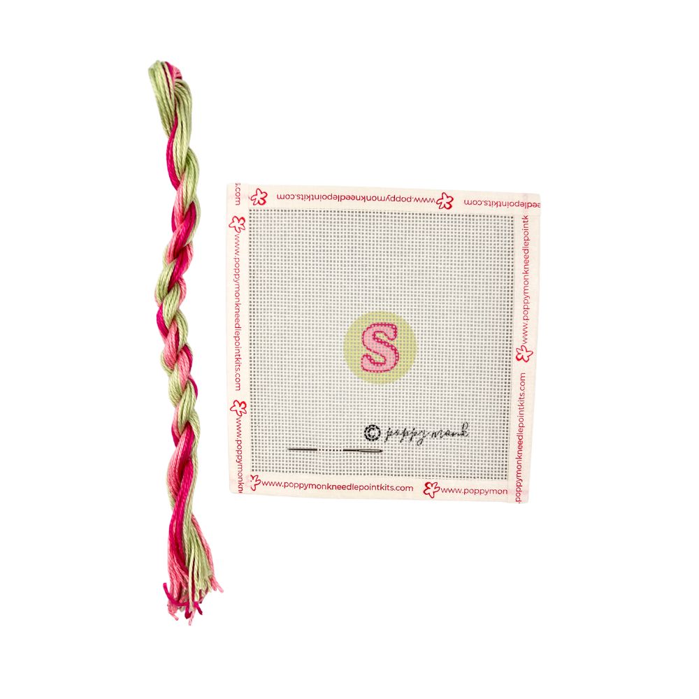 Cross stitch kit with pre-printed pattern and colored threads on a white background