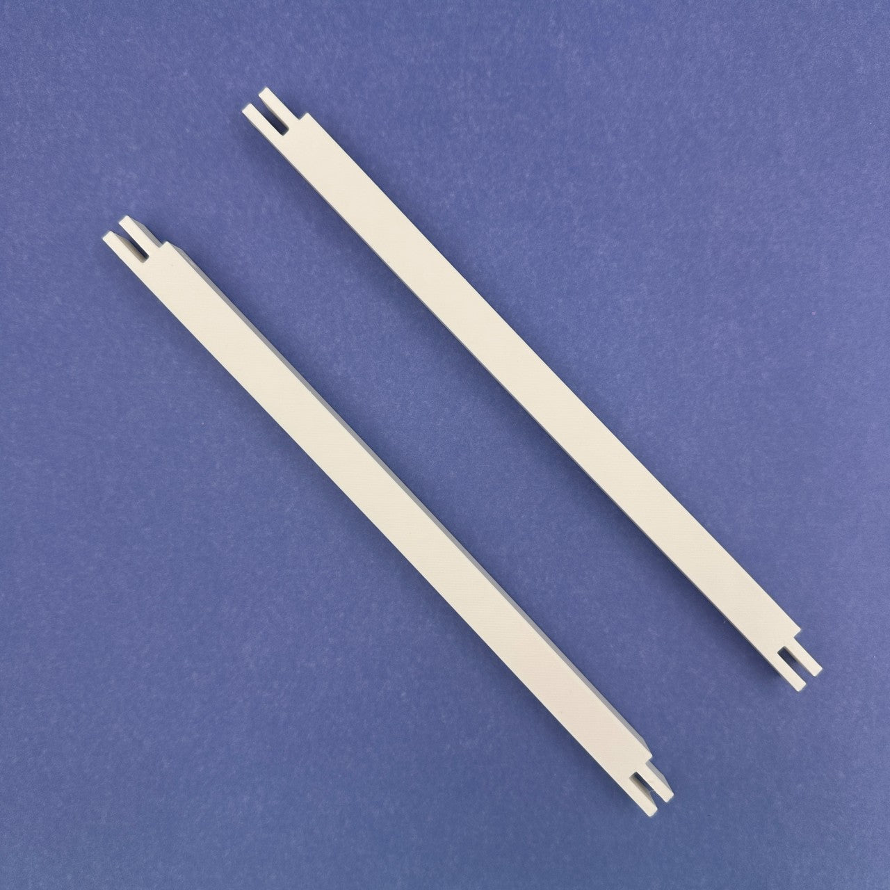 Two white plastic stretcher bars 9 inches on a blue background