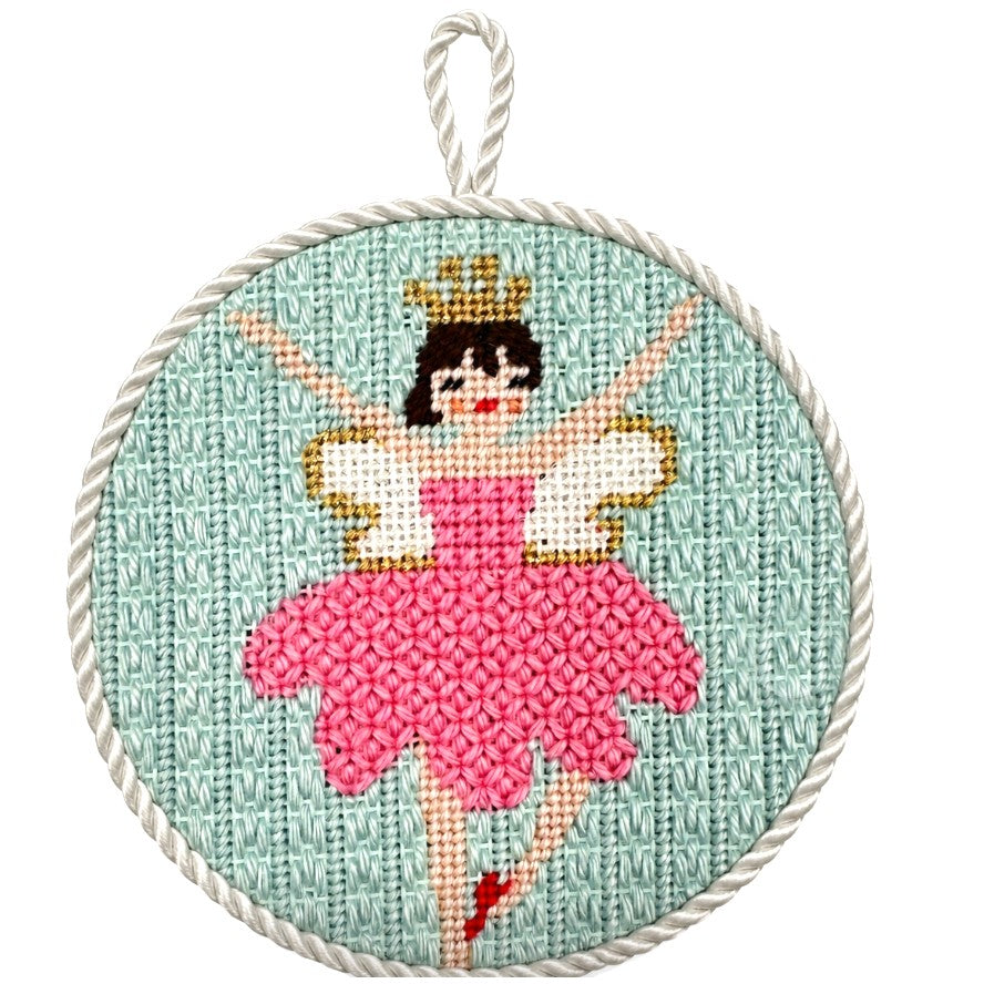 Needlepoint ballerina in a pink dress with a gold crown on a light blue background