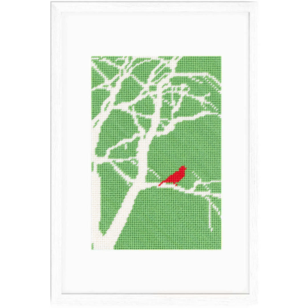 The Red Bird design stitched and in a white frame.