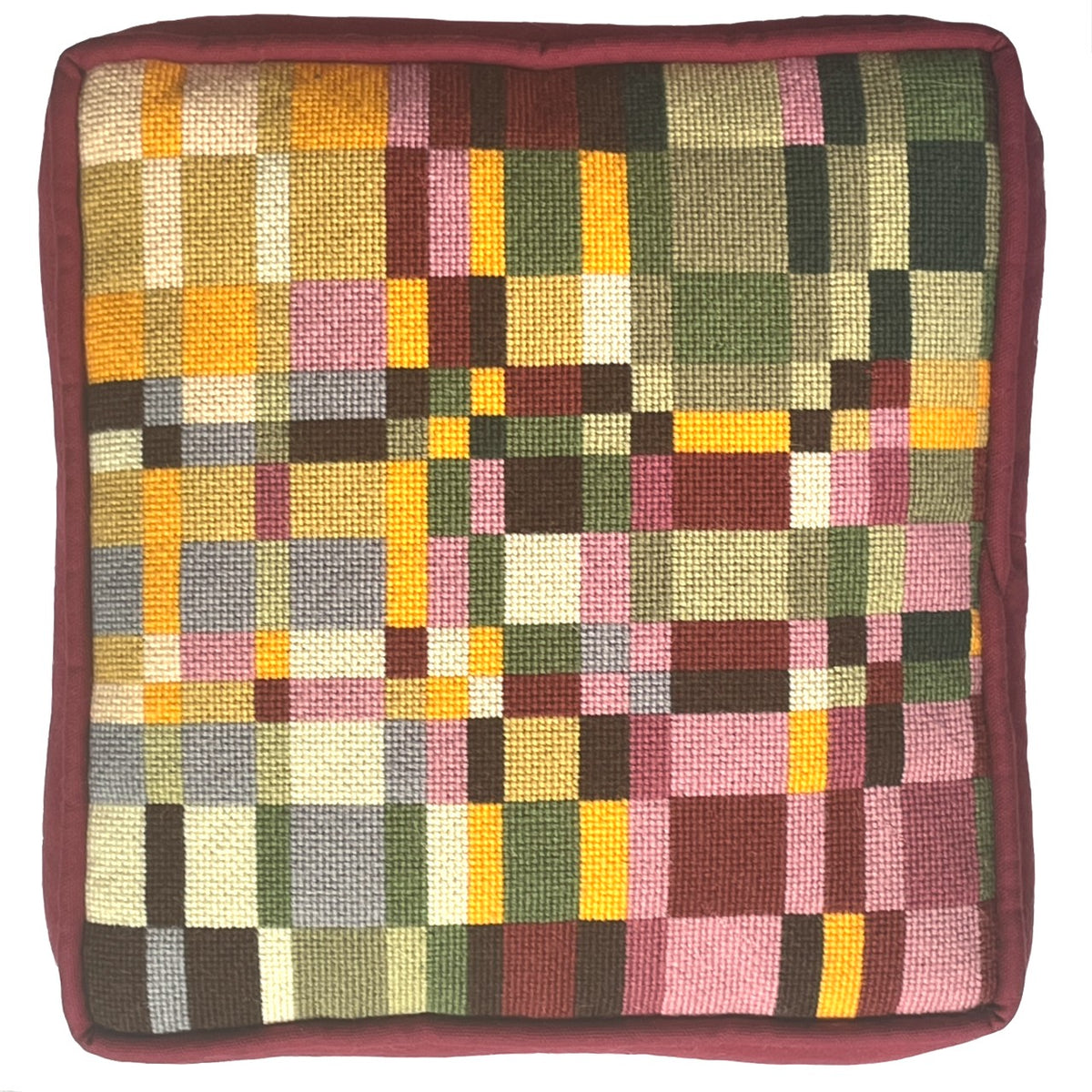 A square needlepoint pillow with geometric design in burgundy, greens and golds