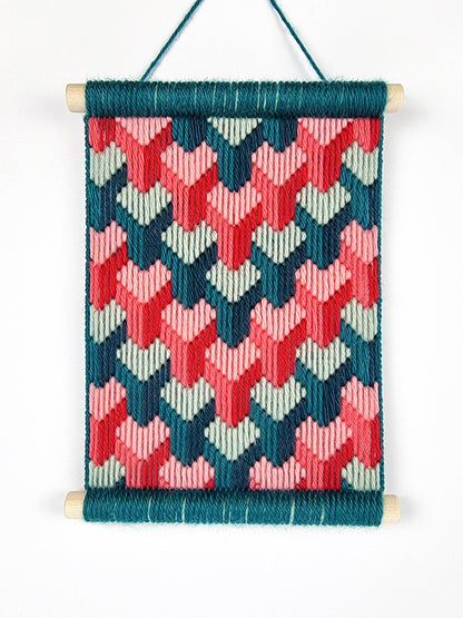 Woven wall hanging with geometric pattern on a white background