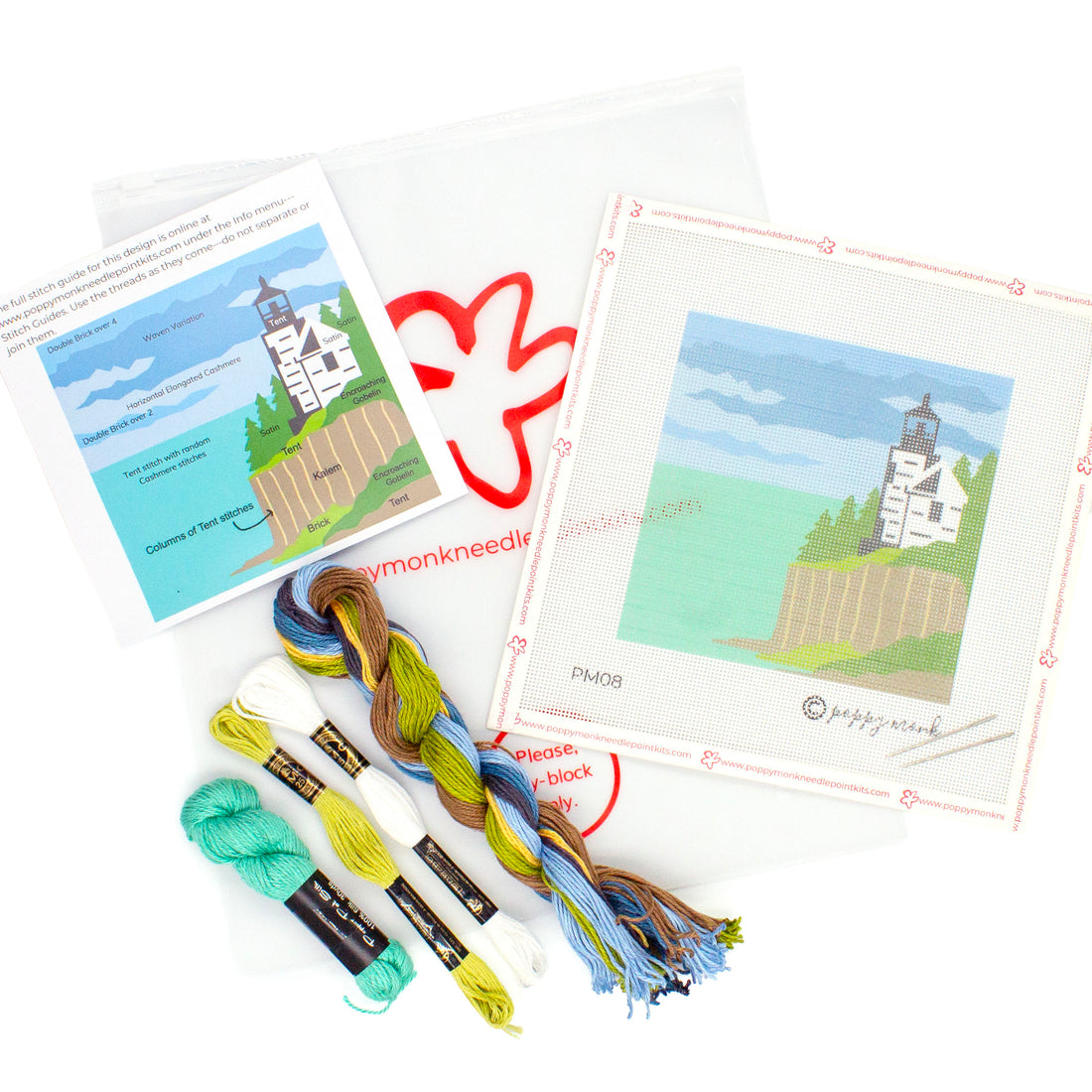 A flat lay image of everything that comes in the Acadia kit. This includes a canvases with the printed Christmas Tree design, a key card showing what stitches go where, and threads on top of a Poppy Monk bag with the poppy logo on it.