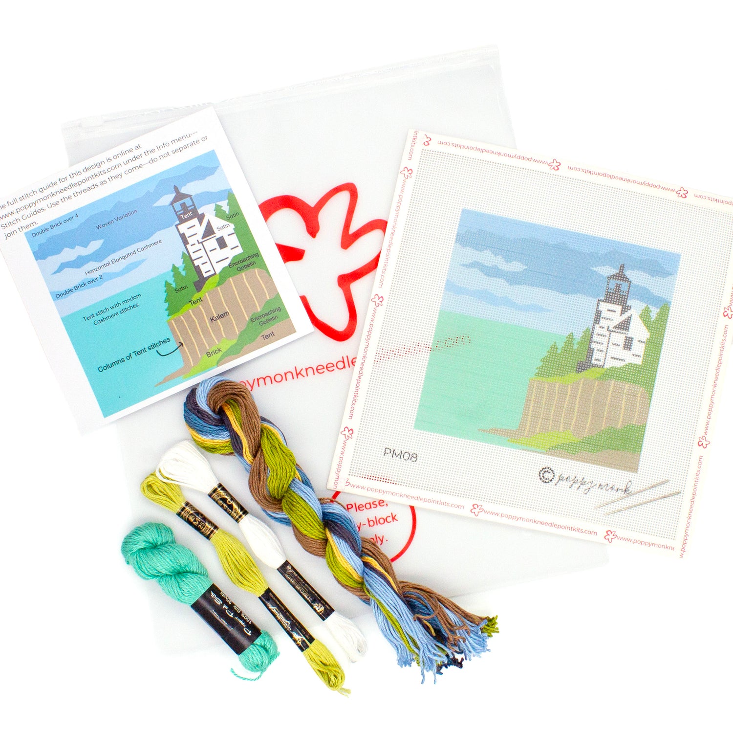 A flat lay image of everything that comes in the Acadia kit. This includes a canvases with the printed Christmas Tree design, a key card showing what stitches go where, and threads on top of a Poppy Monk bag with the poppy logo on it.
