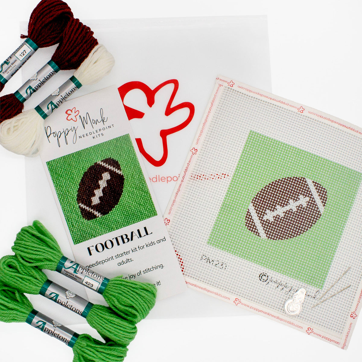 The football kit components on a white background. This includes the printed canvas, colorful threads, instruction brochure, needles, a needle threader, and a bag with the Poppy Monk logo on it.