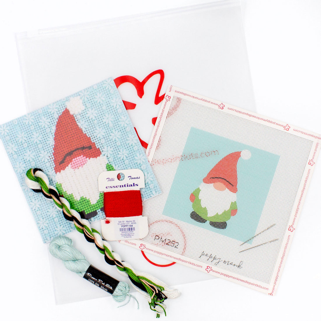 The Gnome kit components on a white background. There is a canvas with the design, an instructional brochure, colorful threads, needles, and clear bag with the Poppy Monk logo on it.