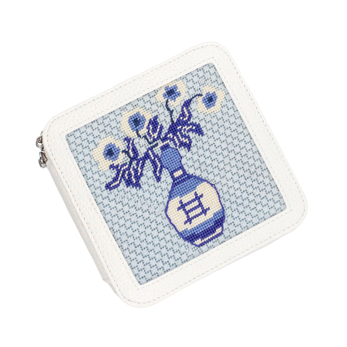 A white faux-leather zippered coin purse featuring a blue and white cross-stitch style illustration of a vase with flowers on the front.