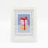 The Macaroons kit stitched and in a white frame with a mat with a decorative blue watercolor bamboo border.