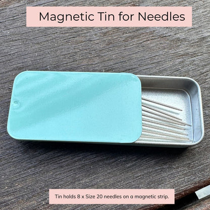 Magnetic tin for needles with a turquoise lid on a wooden surface