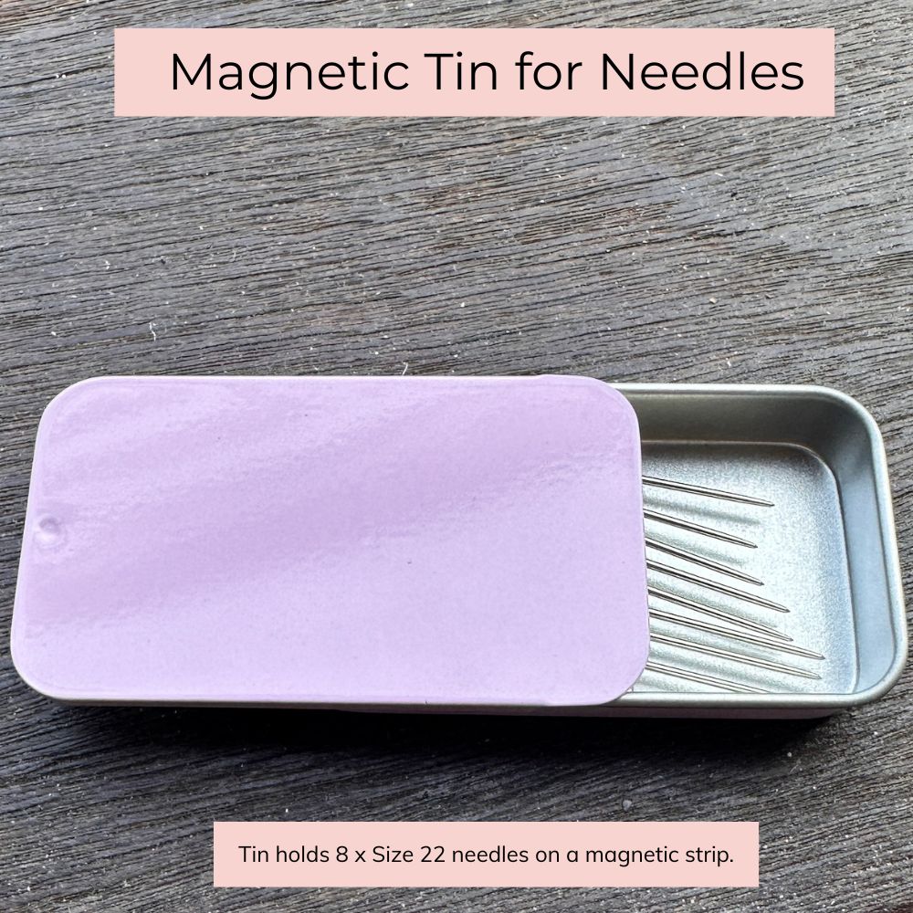 Magnetic tin for needles with a purple lid on a wooden surface