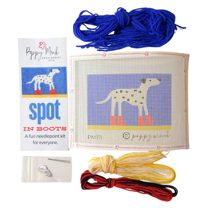 Needlepoint kit with a dog design, yarn, and needle on a white background