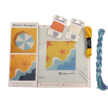 needlepoint kit with a beach scene and starfish and some cards nd skeins of thread.