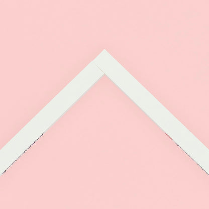 Two stretcher bars joined together making a corner lying on a pink background.