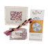 Needlepoint kit with patterned fabric, needle, thread, and Poppy Monk instruction manual on a white background