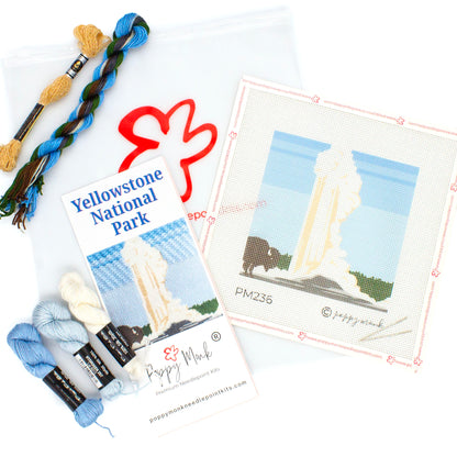 A flat lay of the kit components for the Yellowstone Needlepoint Kit. This includes a canvas with the design printed on it, an instructional brochure, threads, and a clear bag with the Poppy Monk logo on it.
