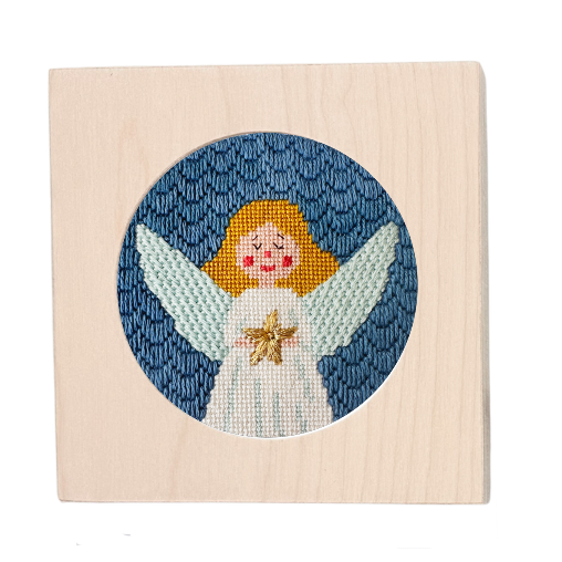 Needlepoint angel design on a wooden block with a blue circular background