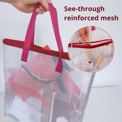 Mesh needlepoint project bag with pink handle and reinforce mesh, showing items inside.