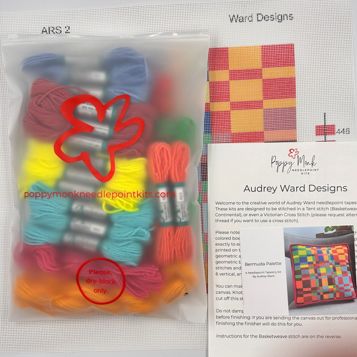 Poppy Monk needlepoint kit with colorful threads and a pattern guide on a white background