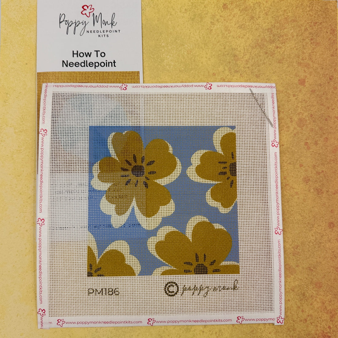 needlepoint canvas of modern flowers on a blue background