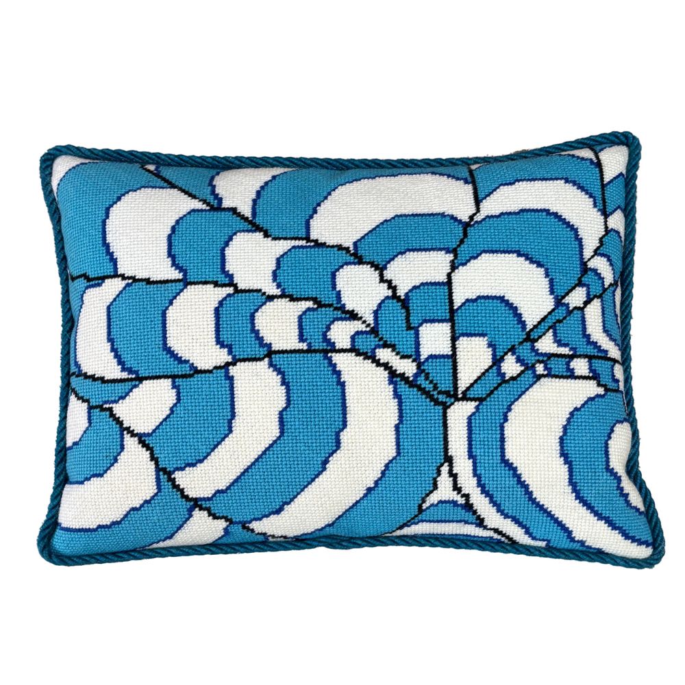 Decorative needlepoint pillow with blue and white wave pattern on a white background