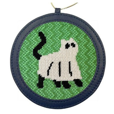 A needlepoint ornament of a cat dressed up as a ghost