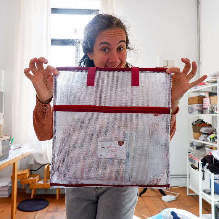 Person holding a mesh needlepoint project bag 