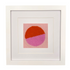 Framed needlepoint with a geometric design of two intersecting circles, one orange and one pink, on a white background.
