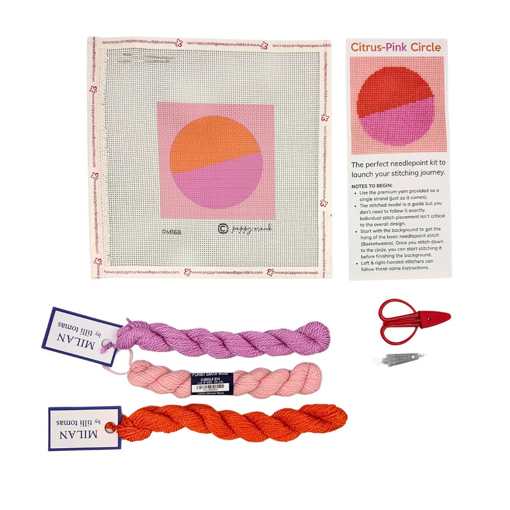 A needlepoint kit with an orange and pink circle with threads and scissors