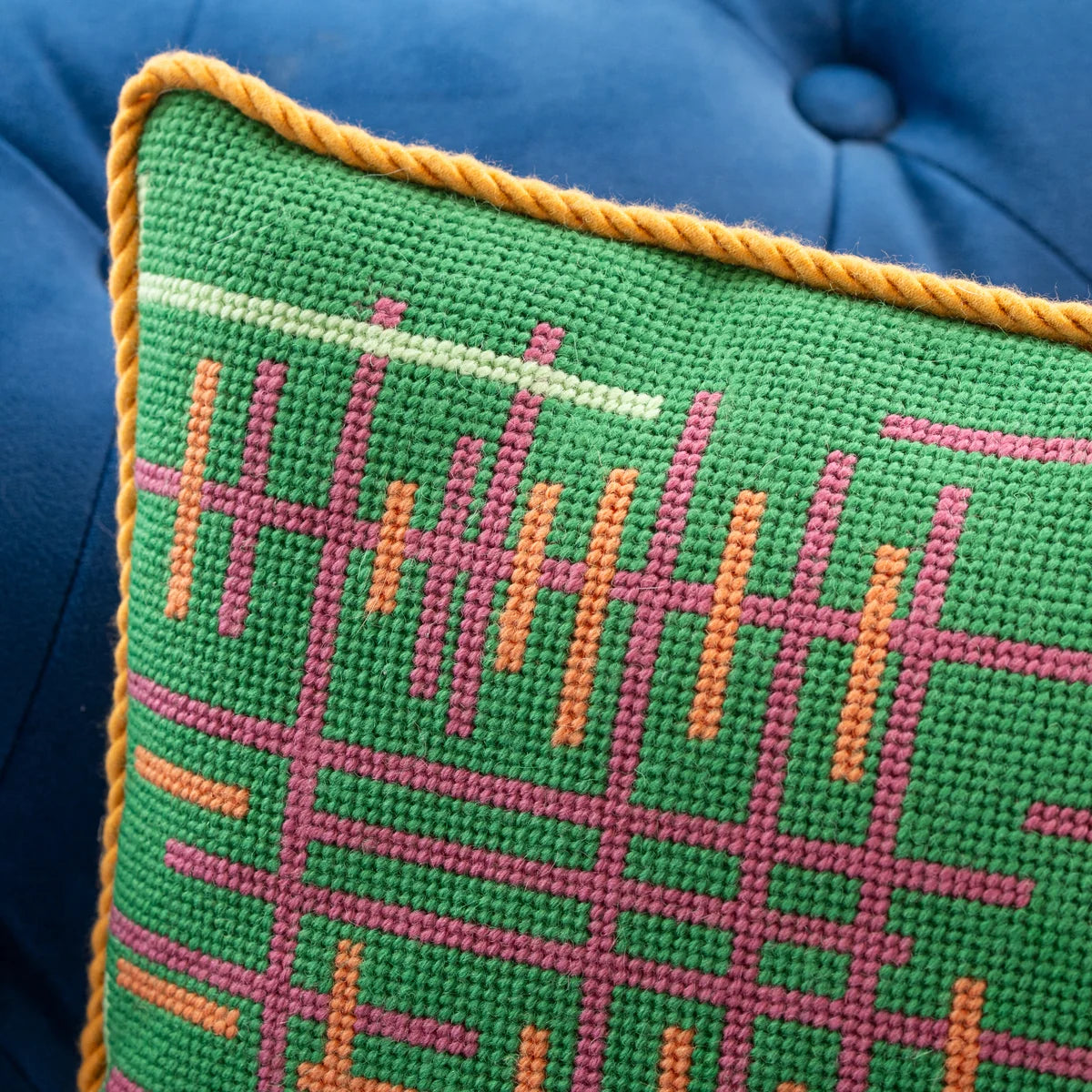 A close up of needlepoint stitches on a pillow