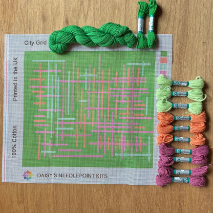 A needlepoint pillow kit of geometric lines on a green background