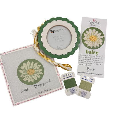 A needlepoint kit bundle with a daisy rund design and a scalloped frame