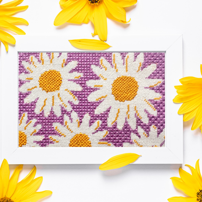 Framed needlepoint design with daisies