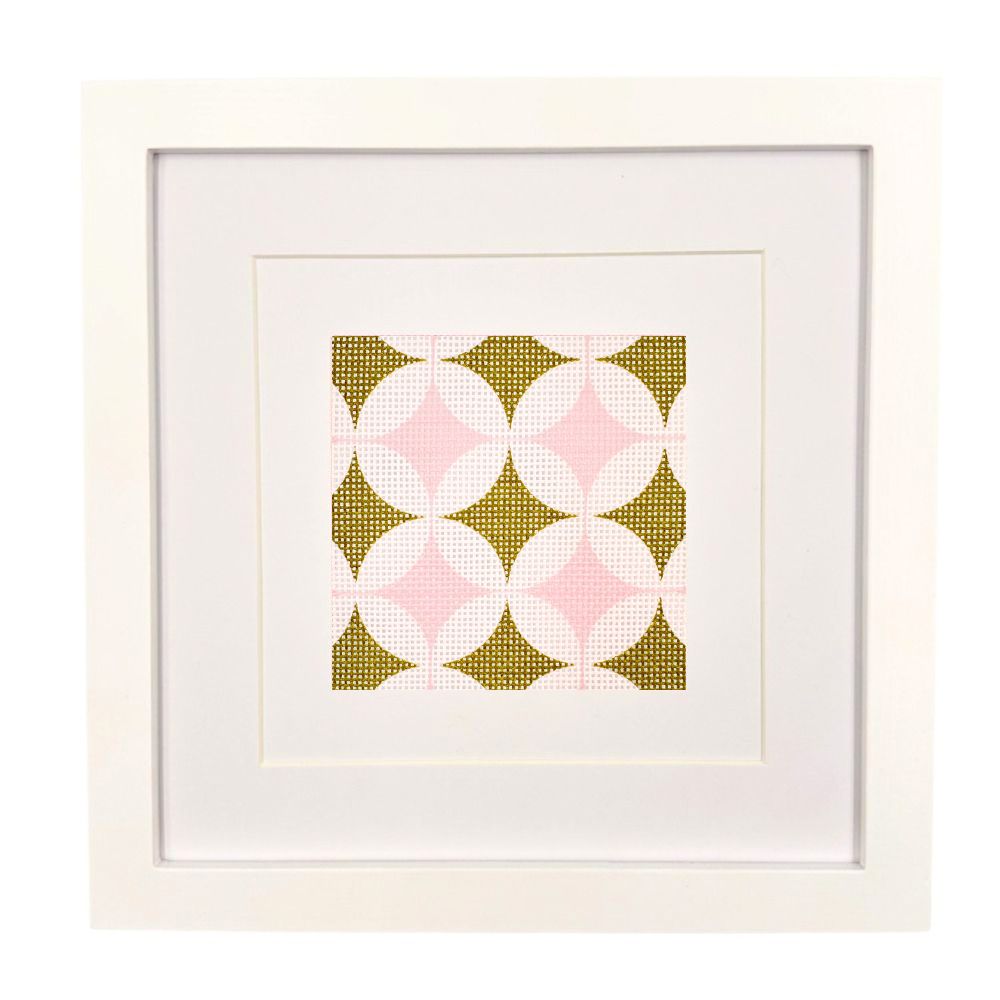 Geometric needlepoint design in olive green and pinks shown in a white frame