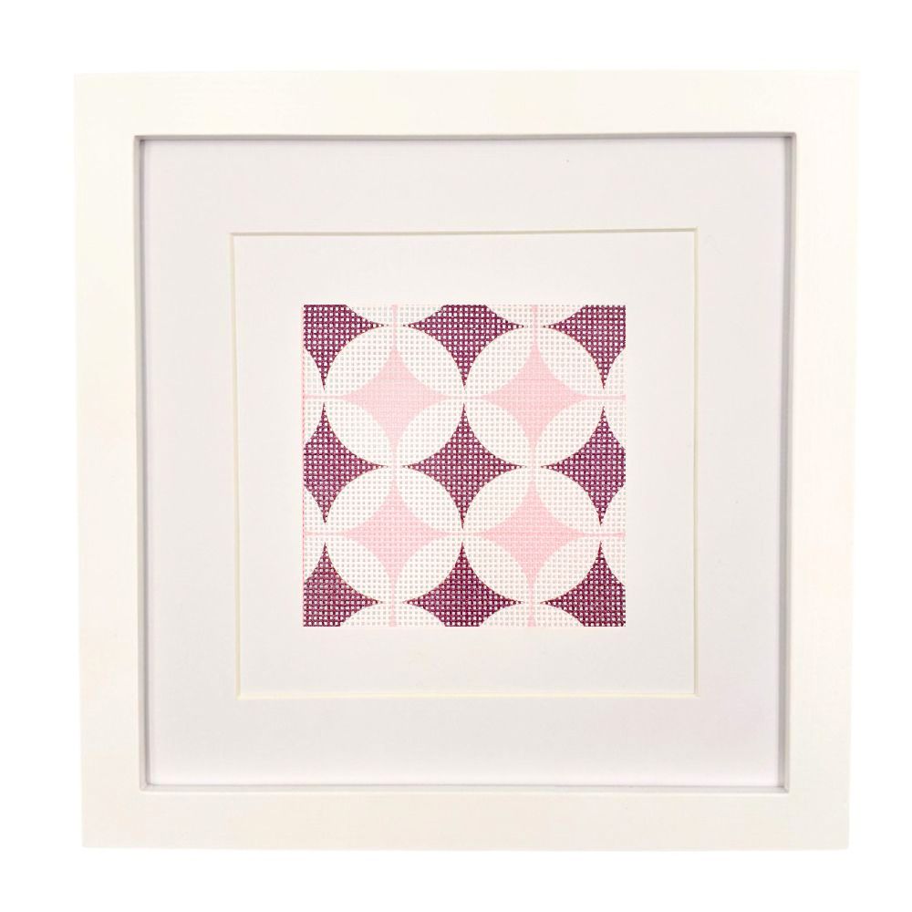 A geometric needlepoint design shown in a white frame