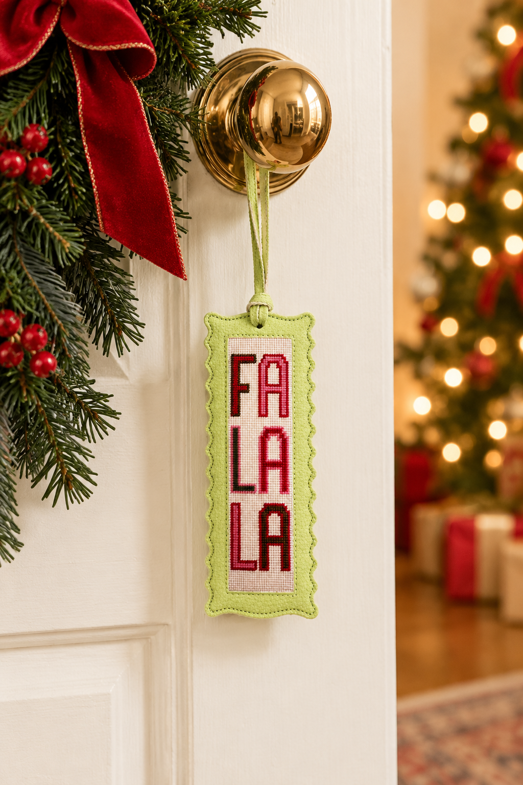 Fa La La needlepoint ornament hanging on a door knob