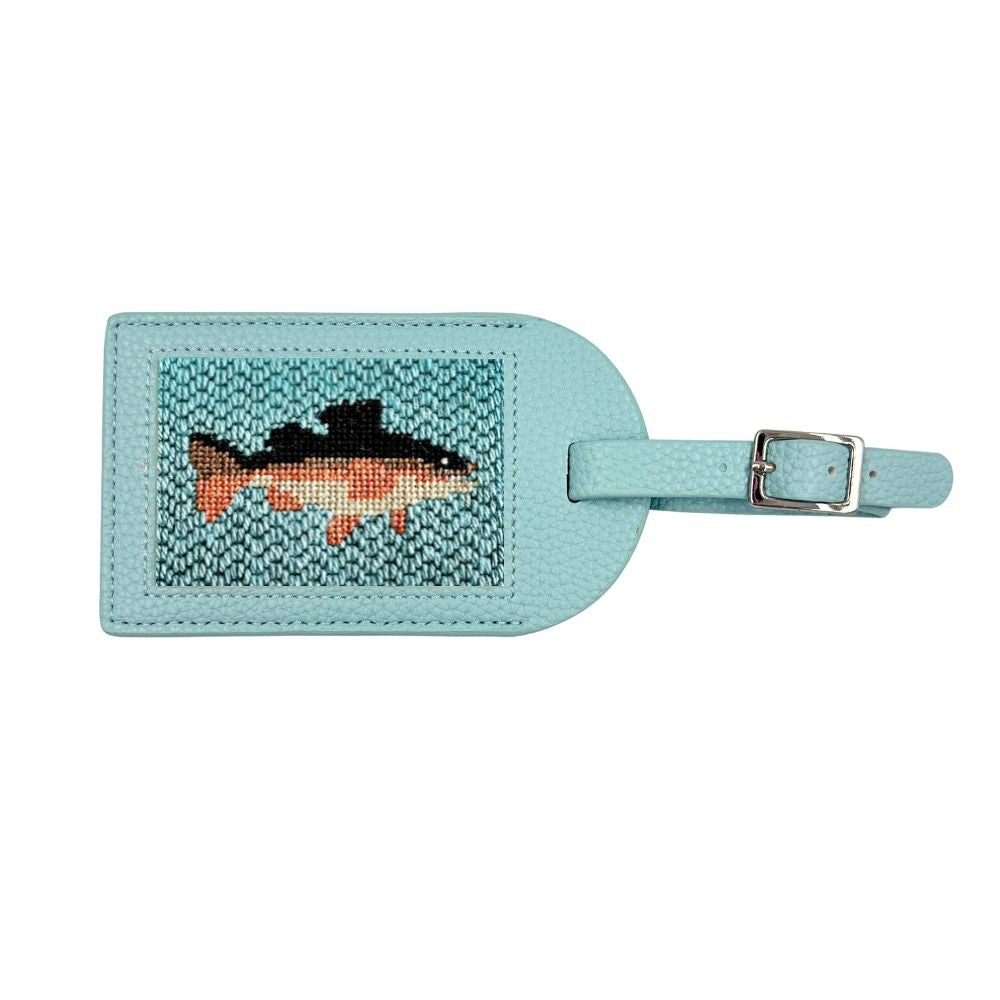 A light blue leather luggage tag featuring a hand-embroidered fish design in black, orange, and teal, with a matching light blue strap and silver buckle.