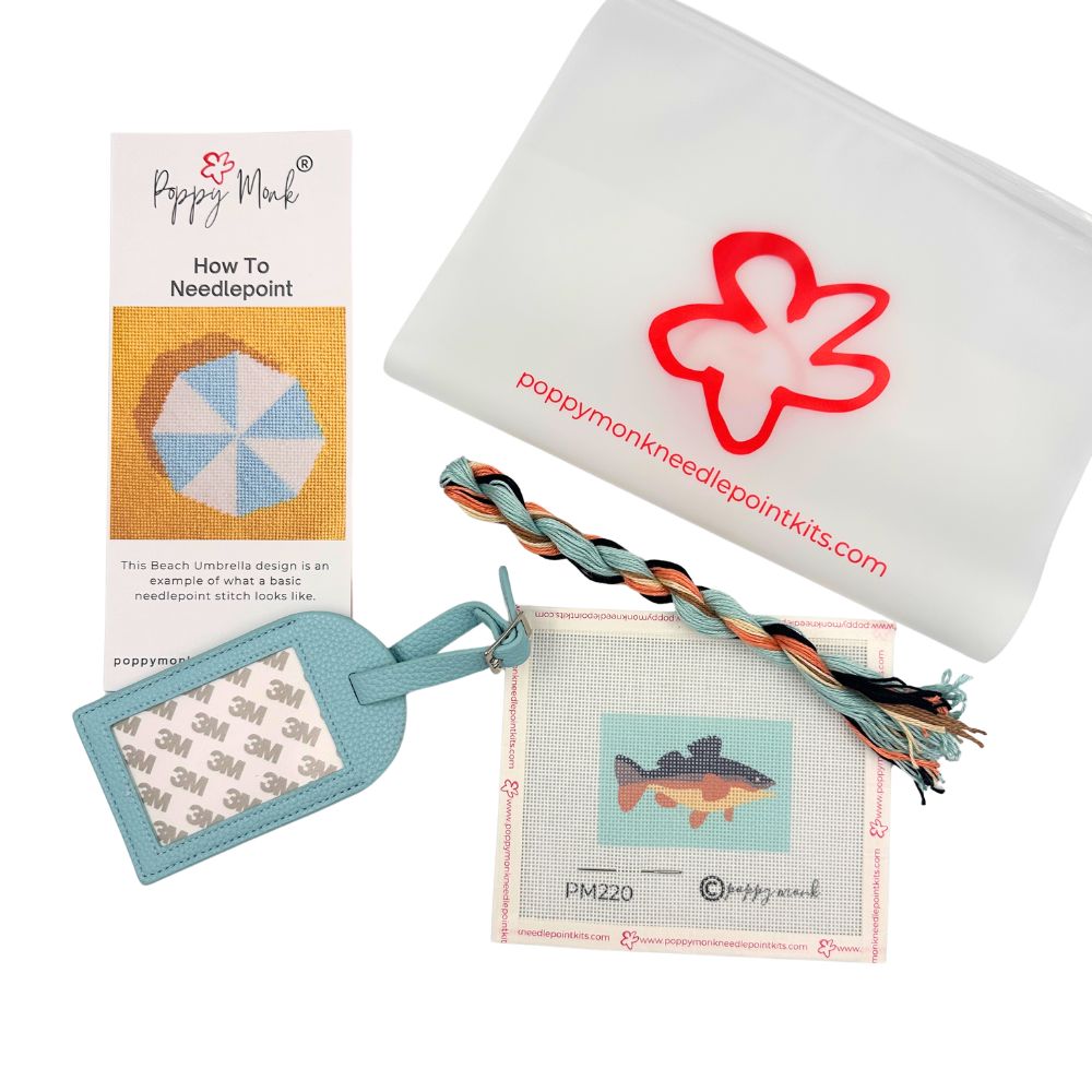 Poppy Monk luggage tag needlepoint kit contents with threads, a fish canvas, instructions and a bag