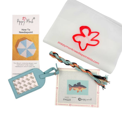 Poppy Monk luggage tag needlepoint kit contents with threads, a fish canvas, instructions and a bag