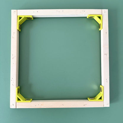 Wooden frame with green brackets on a teal background