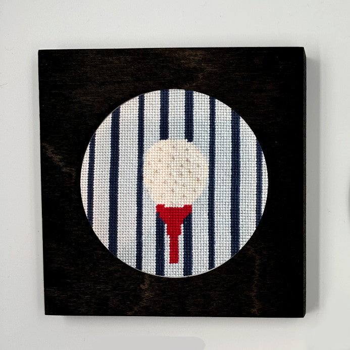 gold ball on a tee needlepoint ornament in a black frame