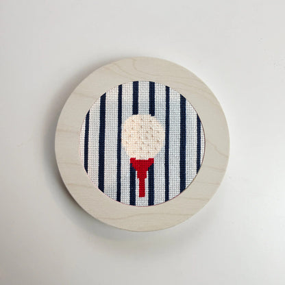 gold ball on a tee needlepoint ornament in a white frame